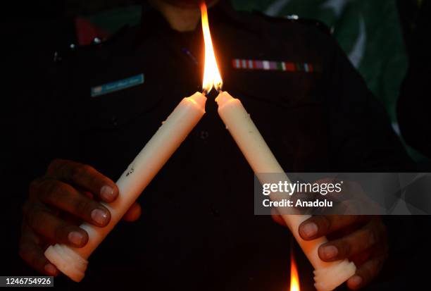 Policemen light candles to pay tribute to the victims of the mosque suicide blast inside a police headquarters in Peshawar, during a vigil in Quetta,...