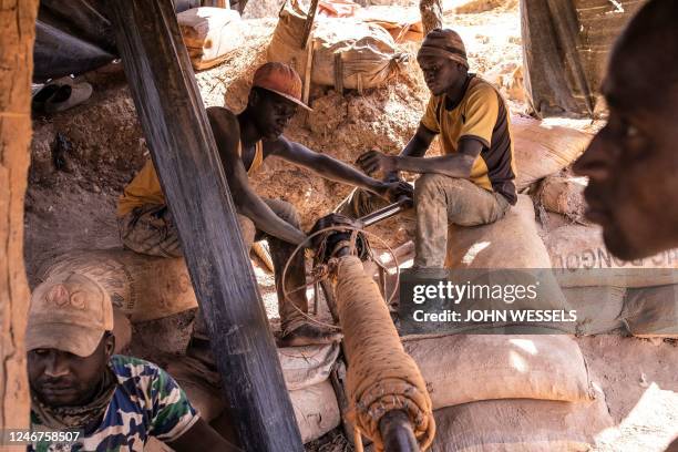 Artisanal gold miners lift a sack of rubble from a pit at the Karakaene gold mine on February 1, 2023. - Karakaene has one of the largest artisanal...