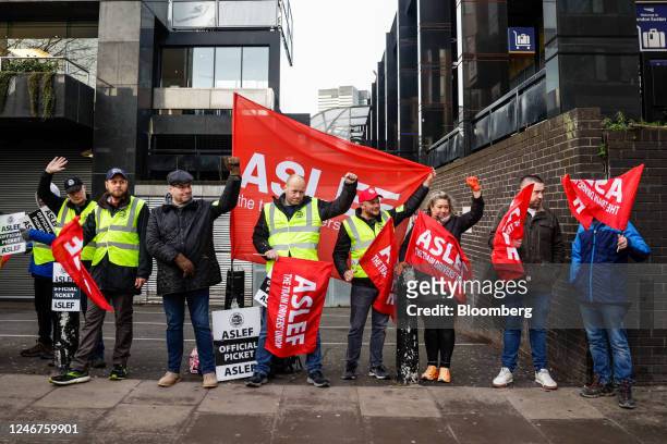 Striking train drivers hold an Associated Society of Locomotive Engineers and Firemen union flags on a picket line outside London Euston railway...