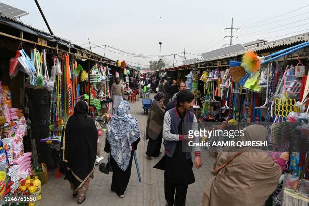 Residents walk throgh a weekly market in Islamabad on February 3, 2023. - Pakistan's Prime Minister Shehbaz Sharif said February 3 the government...
