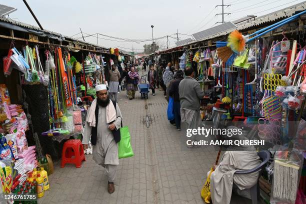 Residents walk throgh a weekly market in Islamabad on February 3, 2023. - Pakistan's Prime Minister Shehbaz Sharif said February 3 the government...