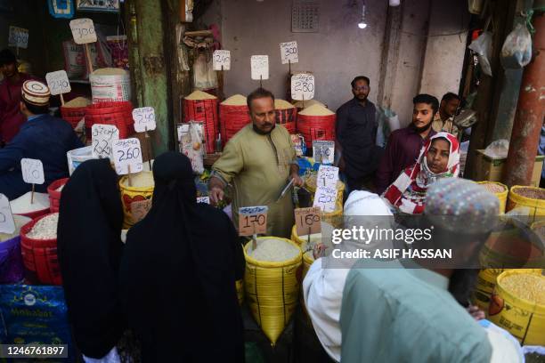 People buy rice at a market in Karachi on February 3, 2023. - Pakistan's Prime Minister Shehbaz Sharif said February 3 the government would have to...