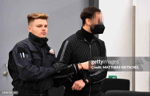 Judicial officer brings defendant Mohamed R into the courtroom of the Higher Regional Court in Dresden, eastern Germany on February 3, 2023 prior to...