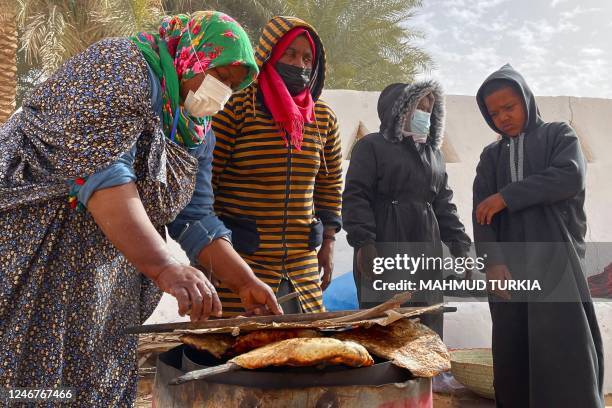 Libyan women bake flatbread near the Libyan town of Ghadames, a desert oasis some 650 kilometres southwest of the capital Tripoli on February 3, 2023.