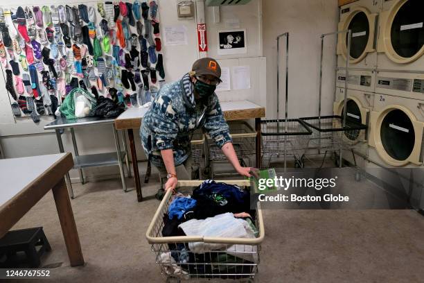 Northampton, MA With the sock gallery in the background, a patron wheels a bin of washed clothing over to the dryers. Jason Foster, owner of...