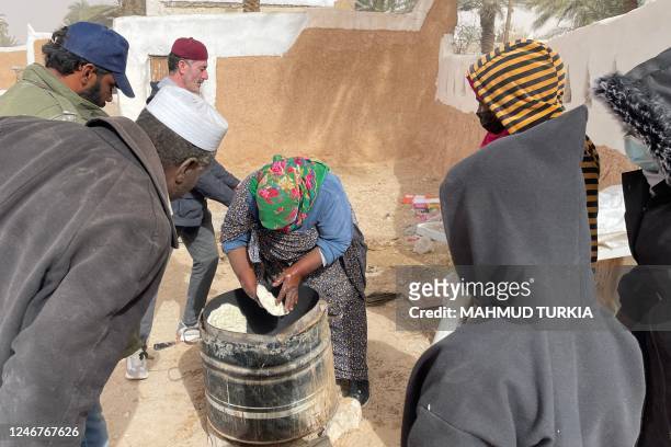 Libyan woman bakes flatbread in the Libyan town of Ghadames, a desert oasis some 650 kilometres southwest of the capital Tripoli on February 3, 2023.