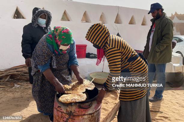 Libyan women bake flatbread in the Libyan town of Ghadames, a desert oasis some 650 kilometres southwest of the capital Tripoli on February 3, 2023.