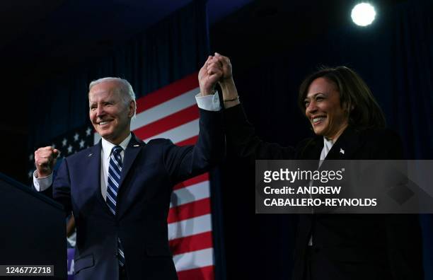 Vice President Kamala Harris and US President Joe Biden hold hands at the Democratic National Committee 2023 Winter meeting in Philadelphia,...