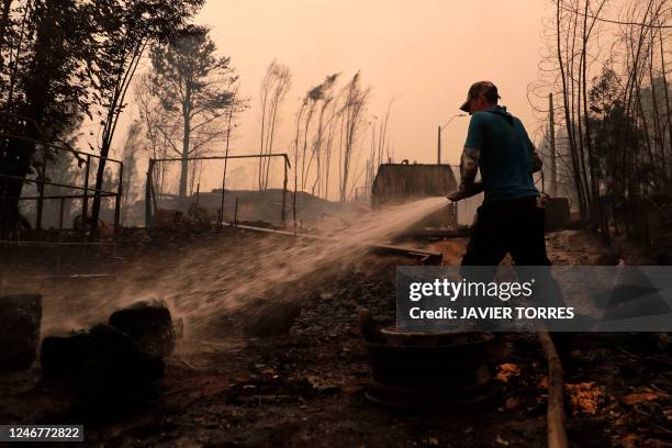 Man puts out a fire in Santa Juana, Concepcion province, Chile on February 3, 2023. - Chile has declared a state of disaster in several...