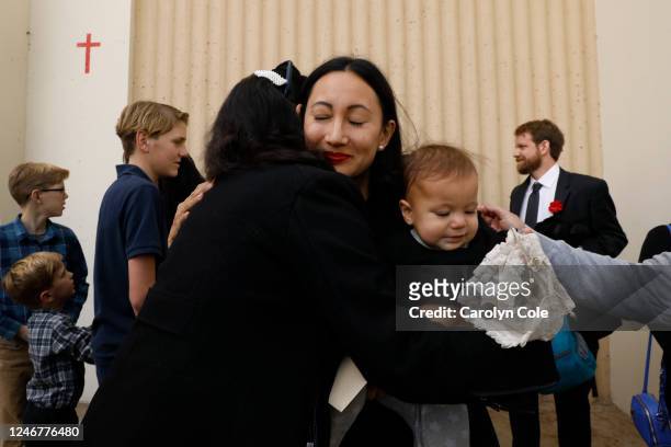 Kristenne Reidy, center, daughter of Valentino Alvero gets a hug while holding her daughter Joan Reidy, right, age 3, after the church service....