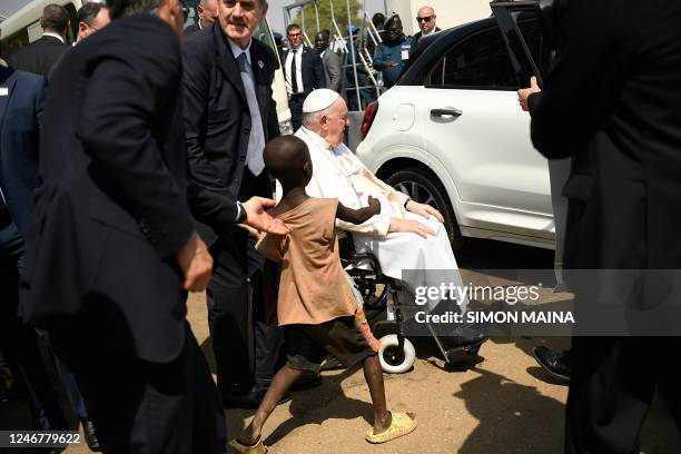 Young South Sudanese boy reaches out to greet Pope Francis while he leaves a meeting with bishops, priests, deacons, consecrated persons and...