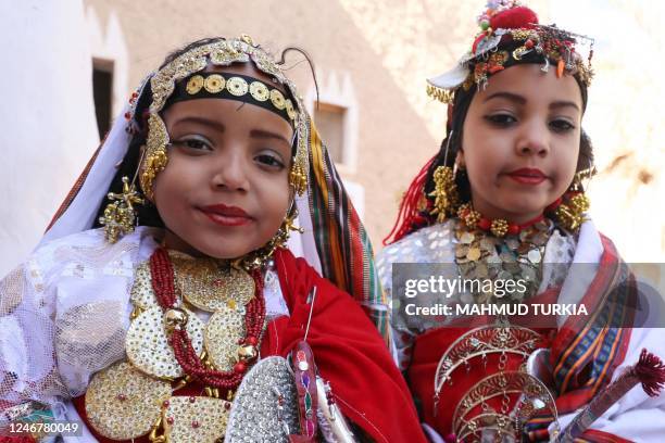 Young girls dressed in colourful dress and traditional jewelery pose for a picture during the opening of the Ghadames festival in the Libyan town of...