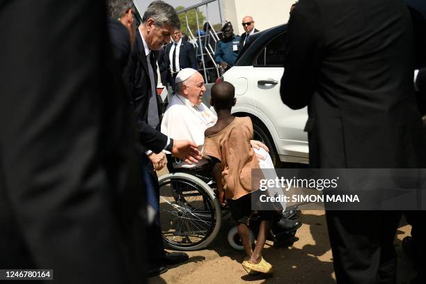 Young South Sudanese boy reaches out to greet Pope Francis while he leaves a meeting with bishops, priests, deacons, consecrated persons and...