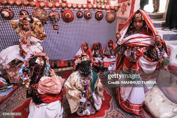 Young girls dressed in colourful dress and traditional jewelery pose for a picture during the opening of the Ghadames festival in the Libyan town of...