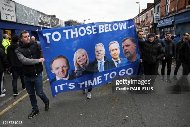 Everton fans protest hold a banner reading "It's time to go..." with portraits of club owner Farhad Moshiri and board members Grant Ingles, Denise...