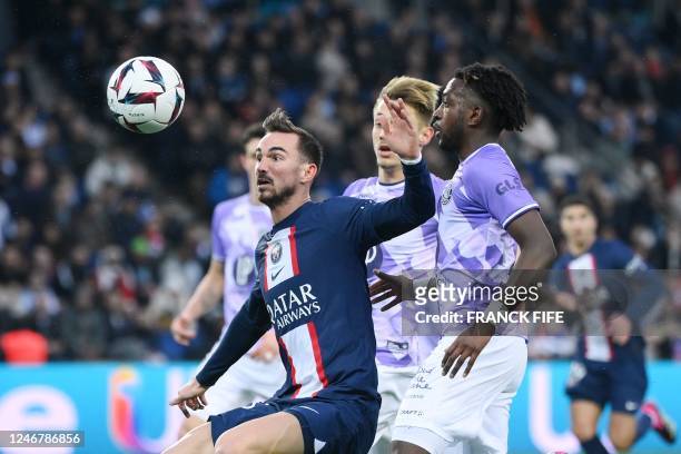 Paris Saint-Germain's Spanish midfielder Fabian Ruiz fights for the ball with Toulouse's Norwegian defender Warren Kamanzi during the French L1...
