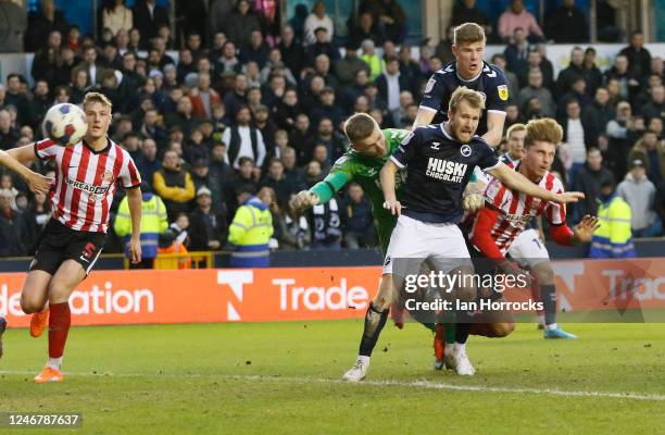 Dennis Cirkin of Sunderland heads his team's first goal but is punched by the Millwall keeper in the process during the Sky Bet Championship match...