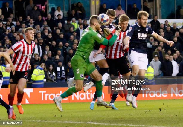 Dennis Cirkin of Sunderland heads his team's first goal but is punched by the Millwall keeper in the process during the Sky Bet Championship match...