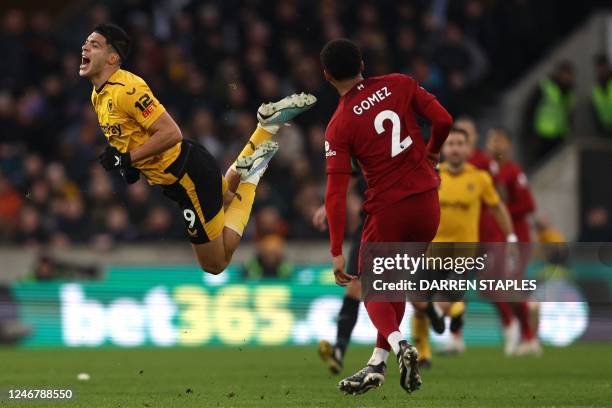Wolverhampton Wanderers' Mexican striker Raul Jimenez is fouled by Liverpool's English defender Joe Gomez during the English Premier League football...