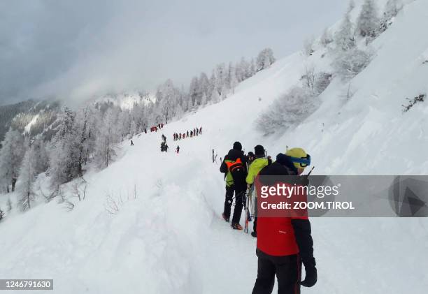 Photo taken on February 4, 2023 shows rescuers during their mission on a slope near Pill, western Austria. - Avalanches in Austria and Switzerland...