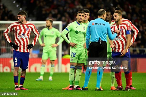 Referee talks to Atletico Madrid's Spanish midfielder Koke during the Spanish league football match between Club Atletico de Madrid and Getafe CF, at...