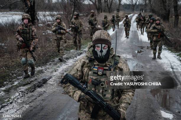 Ukrainian servicemen walk on the road toward their base near the frontline in the Donetsk region on February 4 amid the Russian invasion of Ukraine.