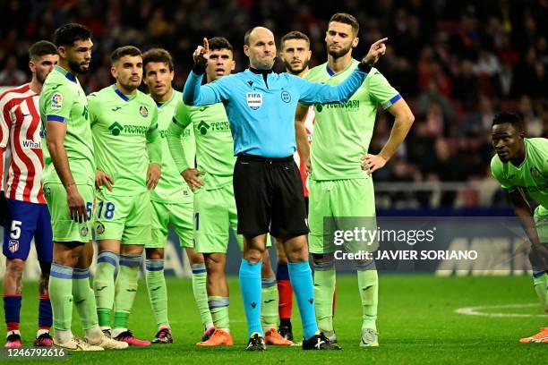 Referee Mateu Lahoz validates Atletico de Madrid's first goal during the Spanish league football match between Club Atletico de Madrid and Getafe CF,...