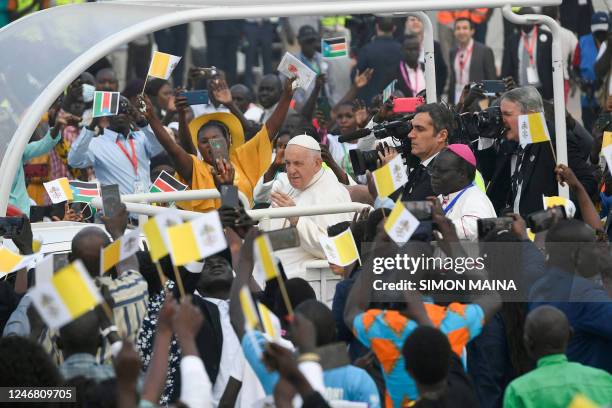 Pope Francis waves as he arrives by popemobile for the holy mass at the John Garang Mausoleum in Juba, South Sudan, on February 5, 2023. - Pope...