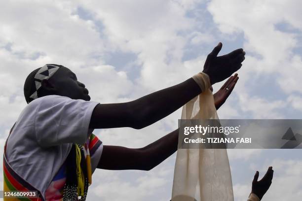 An attendee raises their hands as Pope Francis presides over the holy mass at the John Garang Mausoleum in Juba, South Sudan, on February 5, 2023. -...