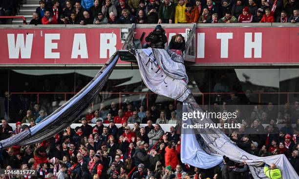 Giant banner got stuck on the TV camera gantry prior to the English Premier League football match between Nottingham Forest and Leeds United at The...