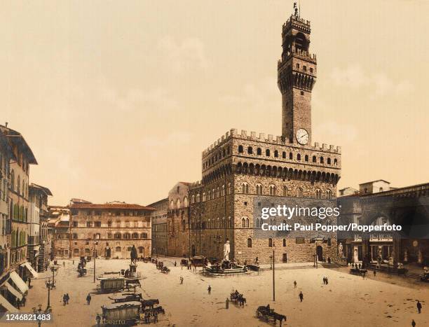 Vintage hand-coloured photograph featuring the Palazzo Vecchio in the Piazza della Signoria, including a copy of Michelangelo's sculpture of David,...