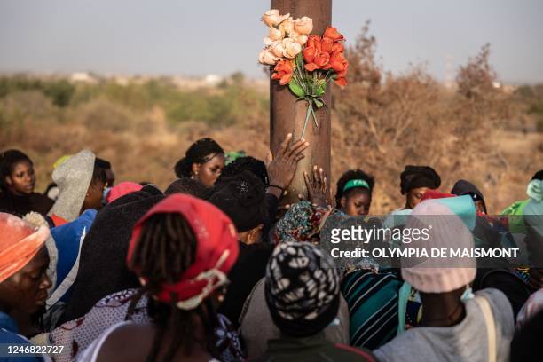 Pilgrims pray at the bottom of a representation of christ on the cross during a pilgrimage to Yagma, on the outskirts of Ouagadougou, on February 5,...