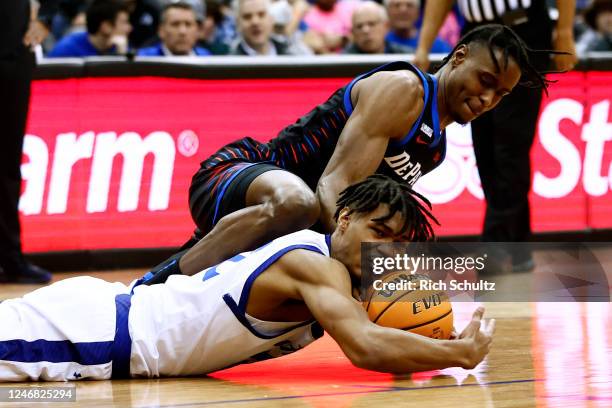 Tae Davis of the Seton Hall Pirates dives on a loose ball and fights off Eral Penn of the DePaul Blue Demons during the second half of a game at...