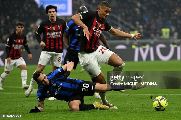 Inter Milan's Turkish midfielder Hakan Calhanoglu tackles AC Milan's German-Finnish defender Malick Thiaw during the Italian Serie A football match...