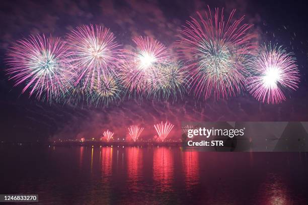 This photo taken on February 5, 2023 shows fireworks lighting up the sky over a bridge across the Yellow Sea during the celebration of the Lantern...