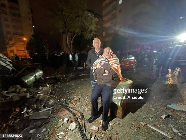 Residents look towards the destroyed building in Yurt neighborhood of Cukurova district after the earthquake on February 6, 2023 in Adana, Turkiye....