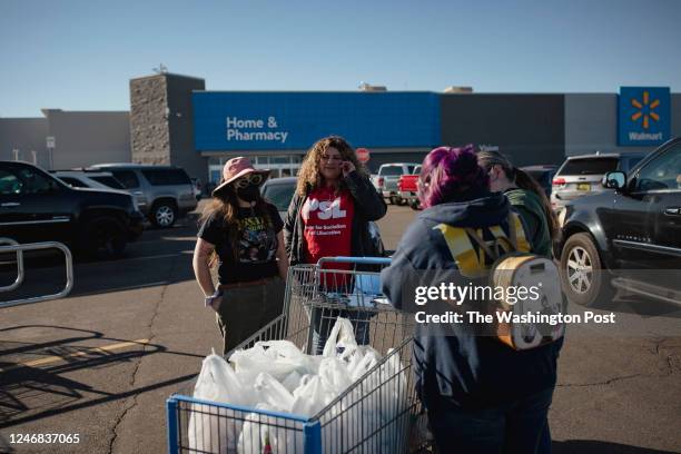 Angelina Crowley and Alyssa Sanchez, members of the Party for Socialism and Liberation, look on as shoppers sign a petition by the Eastern New Mexico...