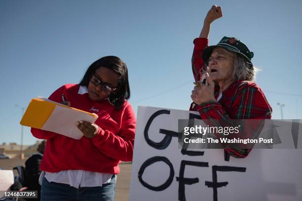 Shaundra Mahan , signs the petition to put abortion access to a ballot measure as Kathleen Daniel holds her fist in the air during a pro-choice rally...