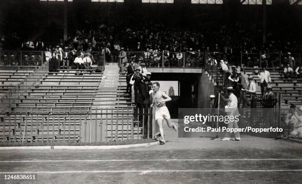 Finland long-distance runner Paavo Nurmi arrives first in the stadium, enroute to a gold medal in the 10,000 metres cross-country event, during the...