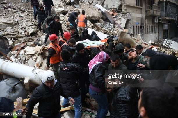 Syrian civil defence members carry an injured woman after rescuing her from the rubble of a collapsed building after an earthquake in the...