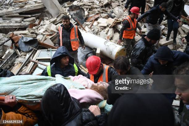 Syrian civil defence members carry an injured woman after rescuing her from the rubble of a collapsed building after an earthquake in the...