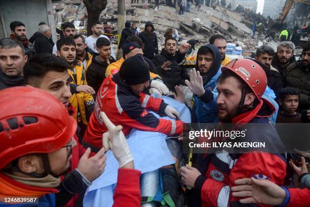 Rescue workers and volunteers pull out a survivor from the rubble in Diyarbakir on February 6 after a 7.8-magnitude earthquake struck the country's...