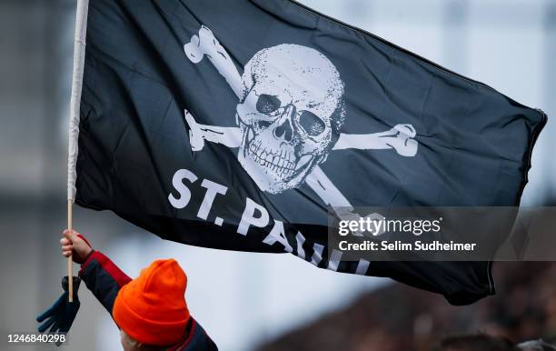 A young St. Pauli supporter waves a skull flag during the Second Bundesliga match between FC St. Pauli and Hannover 96 at Millerntor Stadium on...