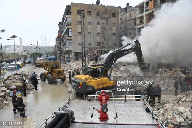 Rescue teams look for survivors under the rubble of a collapsed building after an earthquake in the regime-controlled northern Syrian city of Aleppo...