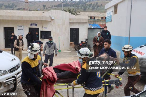 Members of the Syrian civil defence, known as the White Helmets transport an earthquake casualty to a hospital near Syria's rebel-held Bab al-Hawa...