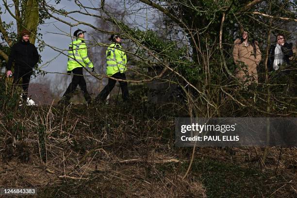 Lancashire police officers walks along the banks of the River Wyre, near St Michael's on Wyre, near Preston, north west England on February 6 as the...