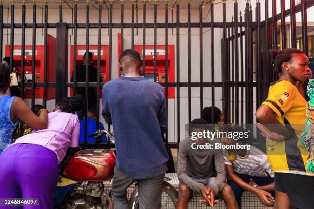 Customers queue to withdraw newly-designed Nigerian naira banknotes from automated teller machines outside a Zenith Bank Plc branch in Lagos,...