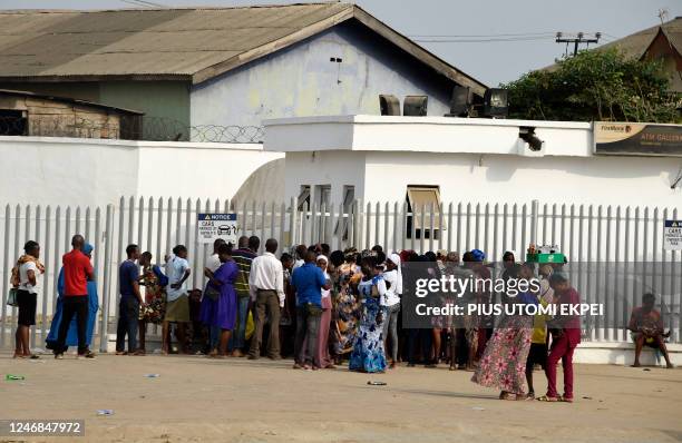 People gather at the premises of a bank to withdraw new banknotes at Ibafo in Ogun State, southwest Nigeria, on February 5, 2023. - As Nigerians...