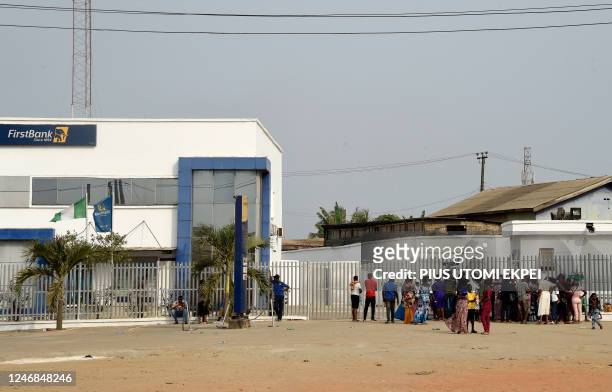 People gather at the premises of a bank to withdraw new banknotes at Ibafo in Ogun State, southwest Nigeria, on February 5, 2023. - As Nigerians...