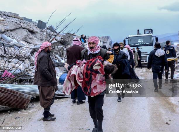 Man carries the dead body of a child who died under the rubble in the earthquake in Idlib, Syria after 7.7 and 7.6 magnitude earthquakes hits...